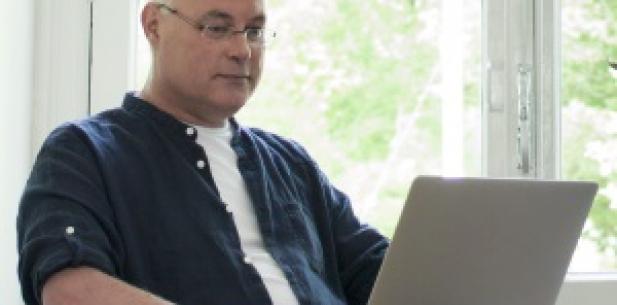 Man met laptop op schoot