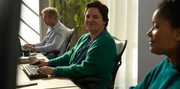 Collega's op kantoor achter de computer