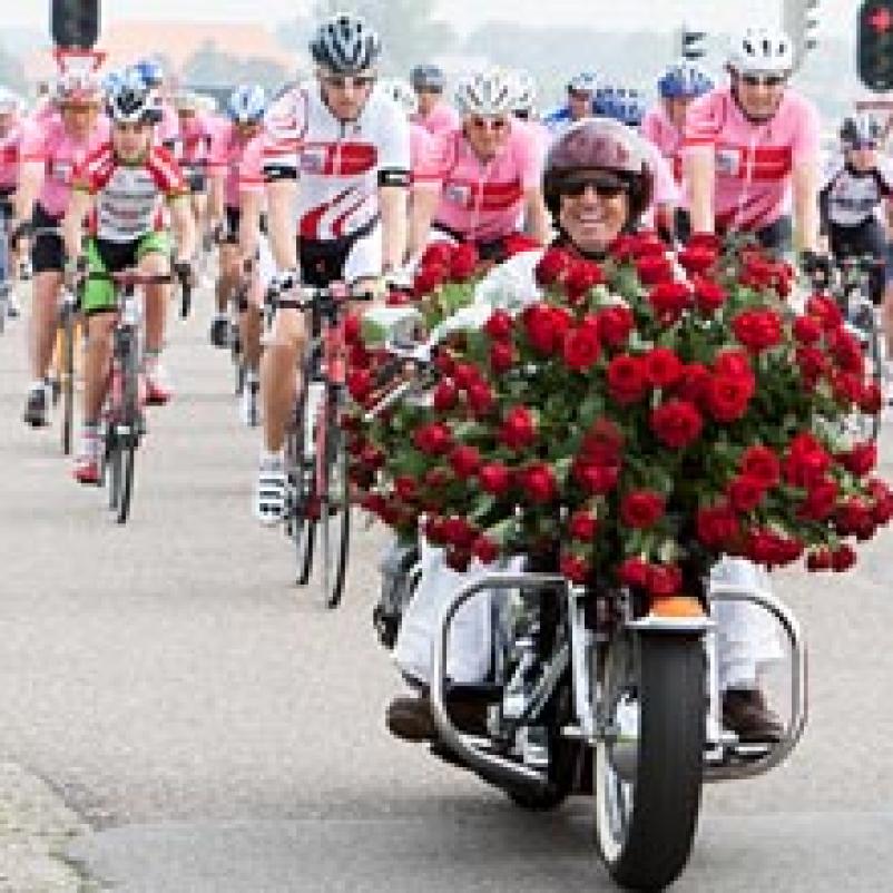 Fietsers achter motor bekleed met rode rozen