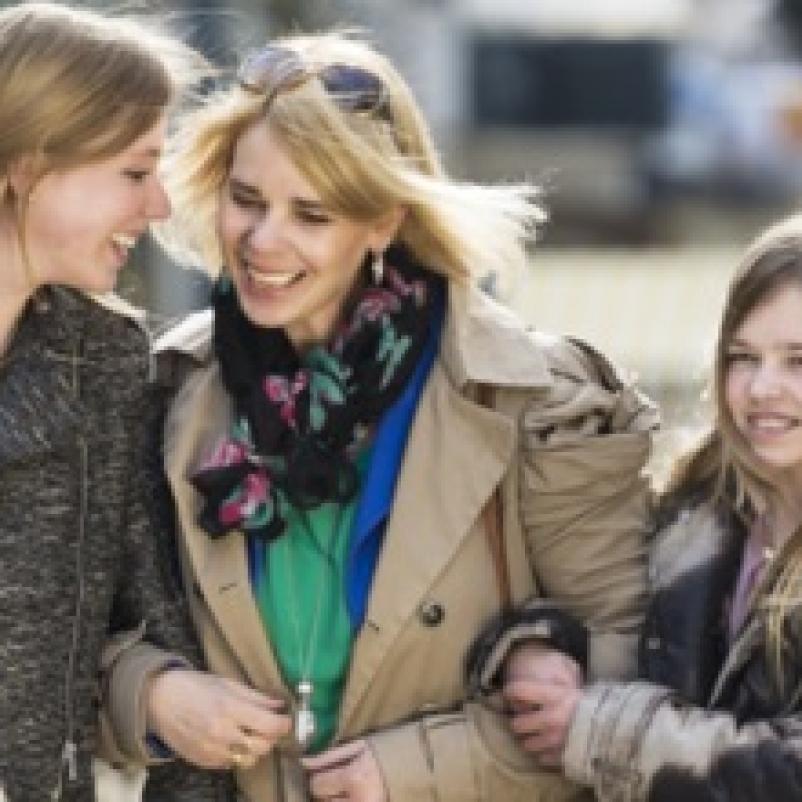 Moeder met dochters lopen gearmd op straat