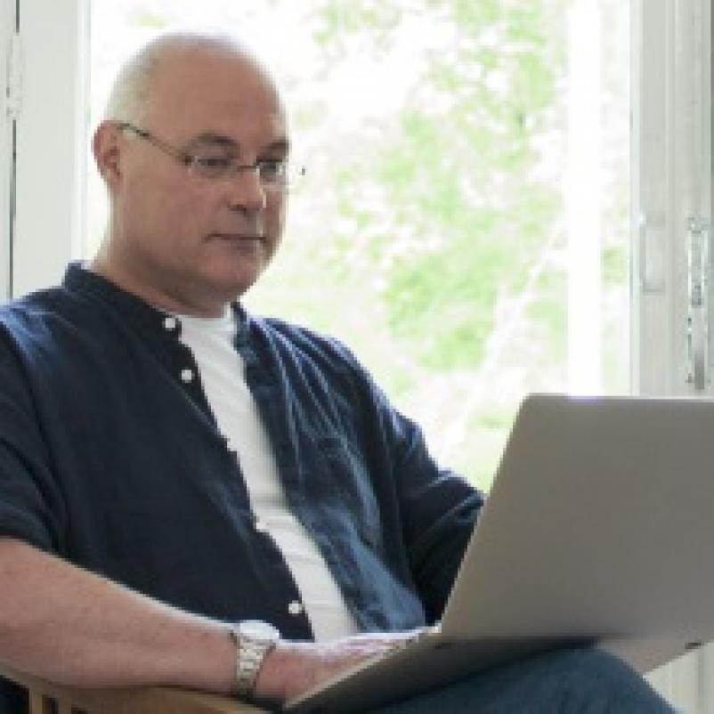 Man met laptop op schoot