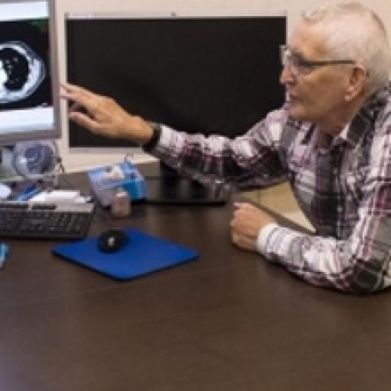 Oudere man bespreekt met dokter eigen scan