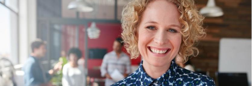 Vrouw op werkvloer met mensen op de achtergrond