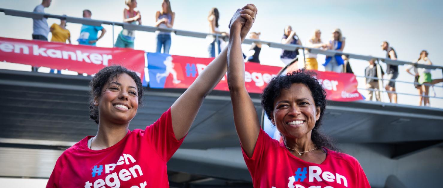 Moeder en dochter hand in hand over de finish evenement voor KWF