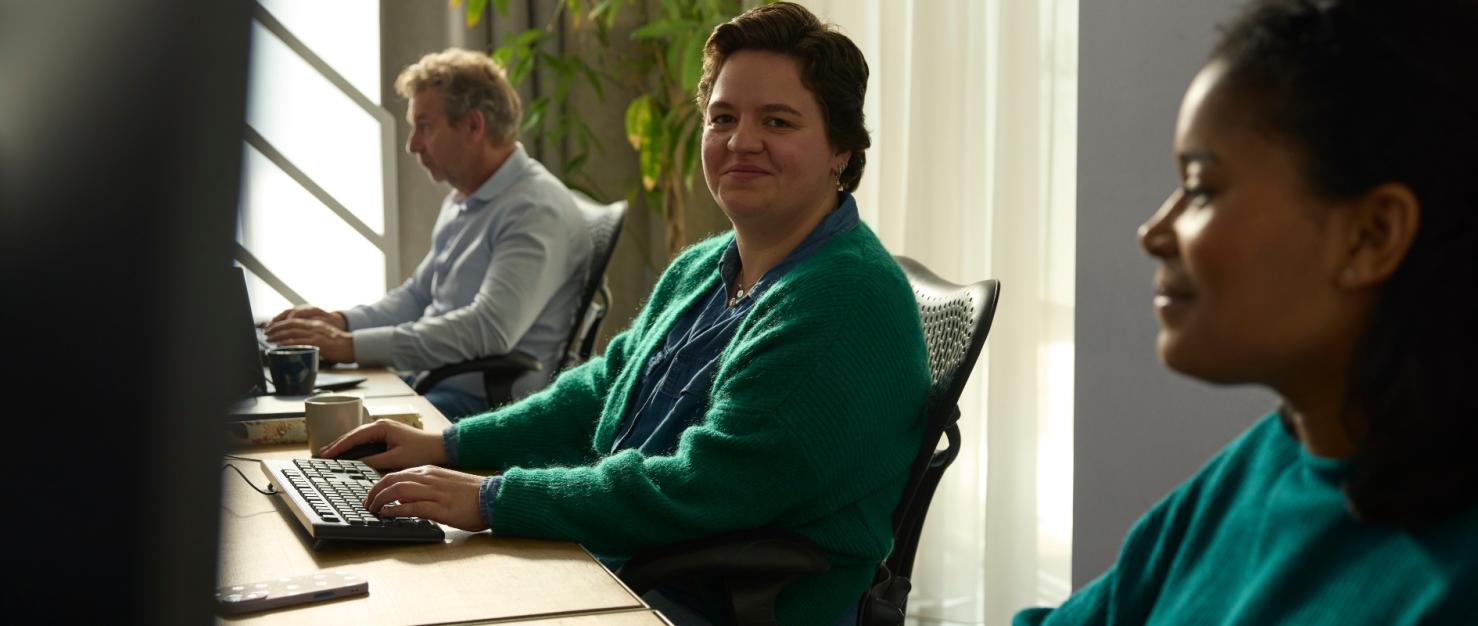 Collega's op kantoor achter de computer