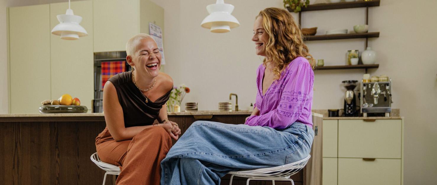 2 vriendinnen lachend in de keuken