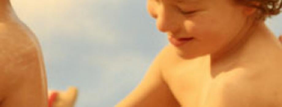 Vier kinderen die elkaar insmeren met zonnebrand